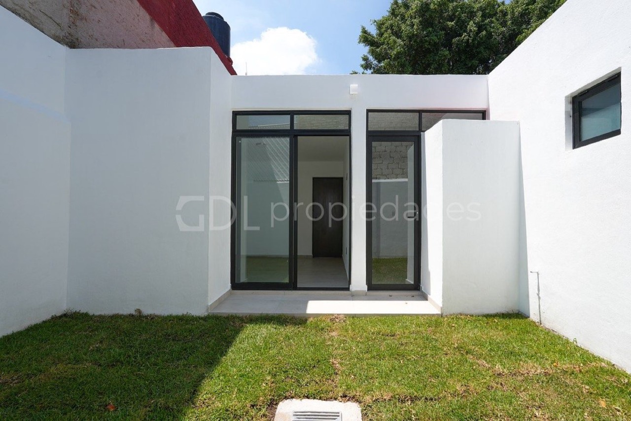 Casa Alcatraz entregada: patio trasero con pasto y puertas de vidrio